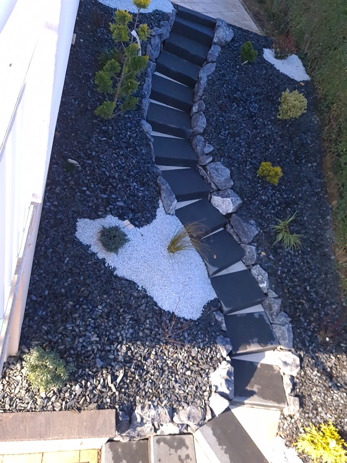 Escalier courbe anthracite et jardin minéral